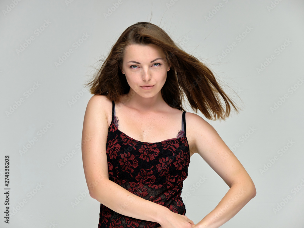 Closeup portrait of pretty girl, brunette woman 30 years old on a light gray background with beautiful dark hair and excellent skin of the face and body. She shows emotions, smiles, wonders. Closeup portrait of pretty girl, brunette woman 30 years old on a light gray background with beautiful dark hair and excellent skin of the face and body. She shows emotions, smiles, wonders.