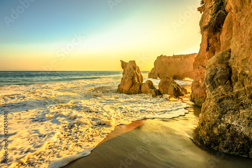 Sunset sea background in California West coast wallpaper. El Matador Beach at beautiful sunset light, CA, United States. Pillars, boulders and rock formations of most photographed Malibu beach.