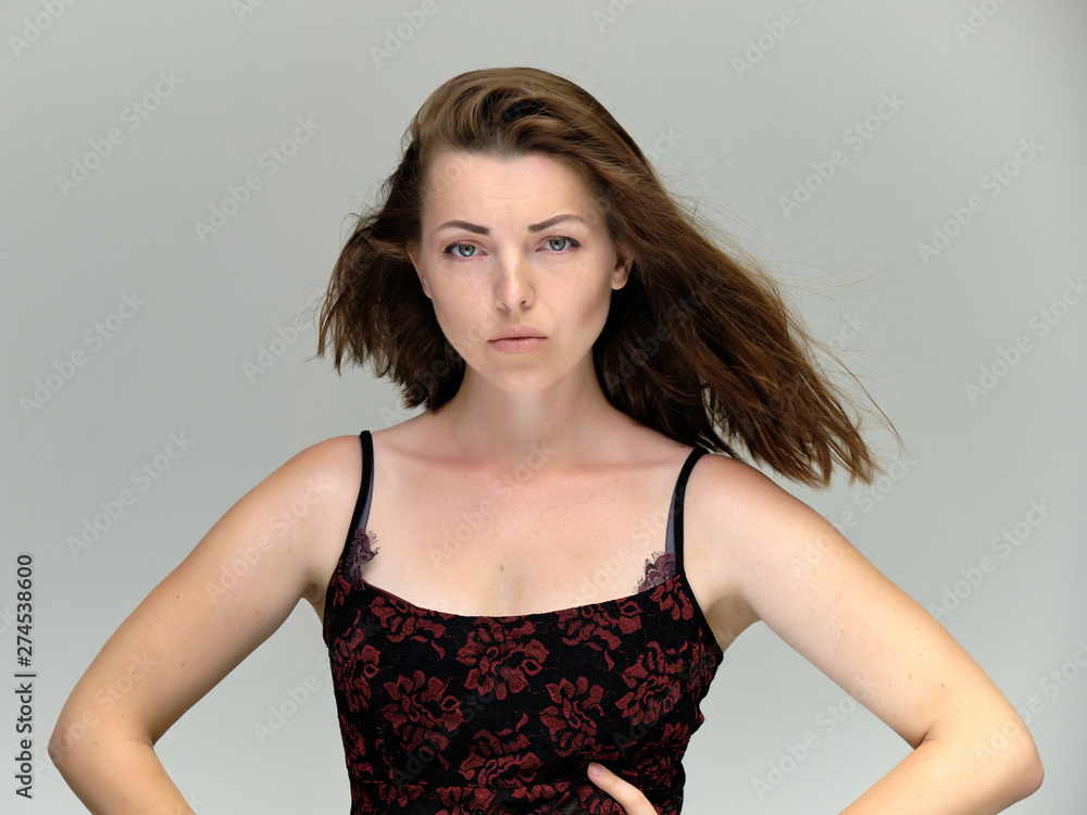Closeup portrait of pretty girl, brunette woman 30 years old on a light gray background with beautiful dark hair and excellent skin of the face and body. She shows emotions, smiles, wonders. Closeup portrait of pretty girl, brunette woman 30 years old on a light gray background with beautiful dark hair and excellent skin of the face and body. She shows emotions, smiles, wonders.