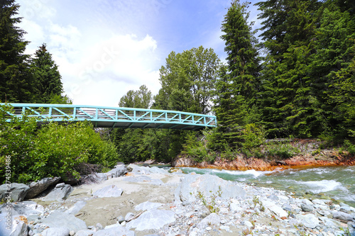 View of pedestrian bridge over Fitzsimmons Creek in Whistler Village, Whistler BC, Canada.