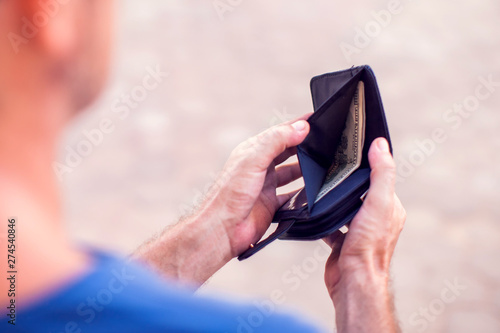 Man holds an empty wallet in hands. Finance problem concept