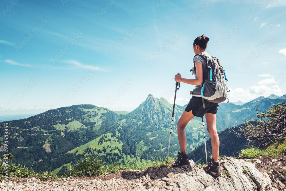 Fit female hiker standing on a mountain ridge - obrazy, fototapety, plakaty 
