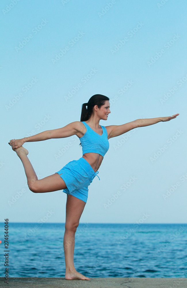 Fototapeta premium Jeune femme faisant son Yoga face à la mer