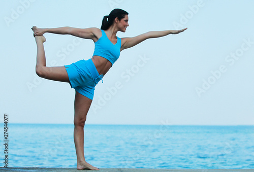 Jeune femme faisant son Yoga face à la mer