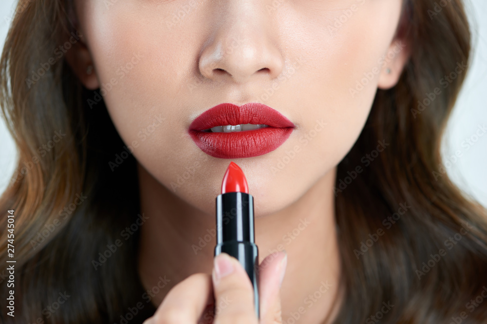 Detail of a beautiful woman applying lipstick Detail of a beautiful woman applying lipstick