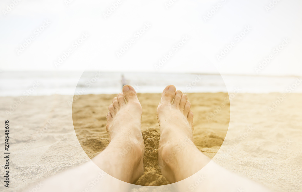 Man is relaxing barefoot at the beach. Guy's legs on the sand. Waves at the ocean side. Coastline in the clouds and sun. Summer vacation. Travel concept. Man is relaxing barefoot at the beach. Guy's legs on the sand. Waves at the ocean side. Coastline in the clouds and sun. Summer vacation. Travel concept.