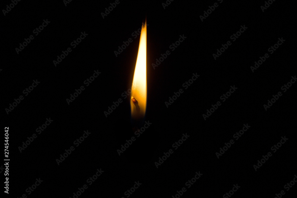 Candle flame on a black background.A burning candle in the night background. Candle flame on a black background.A burning candle in the night background.