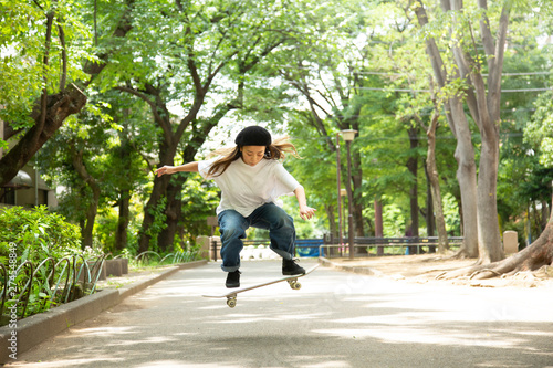 緑道でスケートボードを楽しむ若い女性 photo