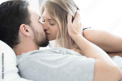 Young couple kissing in the bed .loving couple in bedroom © saksit
