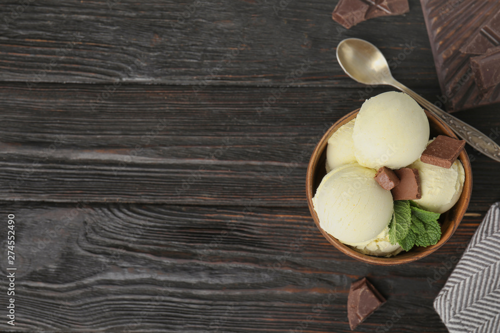 Delicious vanilla ice cream with chocolate and mint served on wooden table, flat lay. Space for text Delicious vanilla ice cream with chocolate and mint served on wooden table, flat lay. Space for text