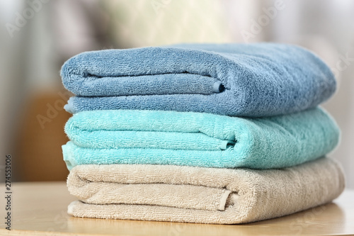 Stack of folded clean soft towels on table indoors, closeup © New Africa
