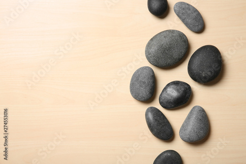 Spa stones on wooden background, top view. Space for text