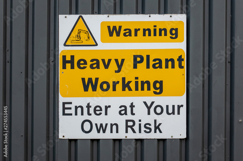 Heavy plant working warning sign on an industrial unit