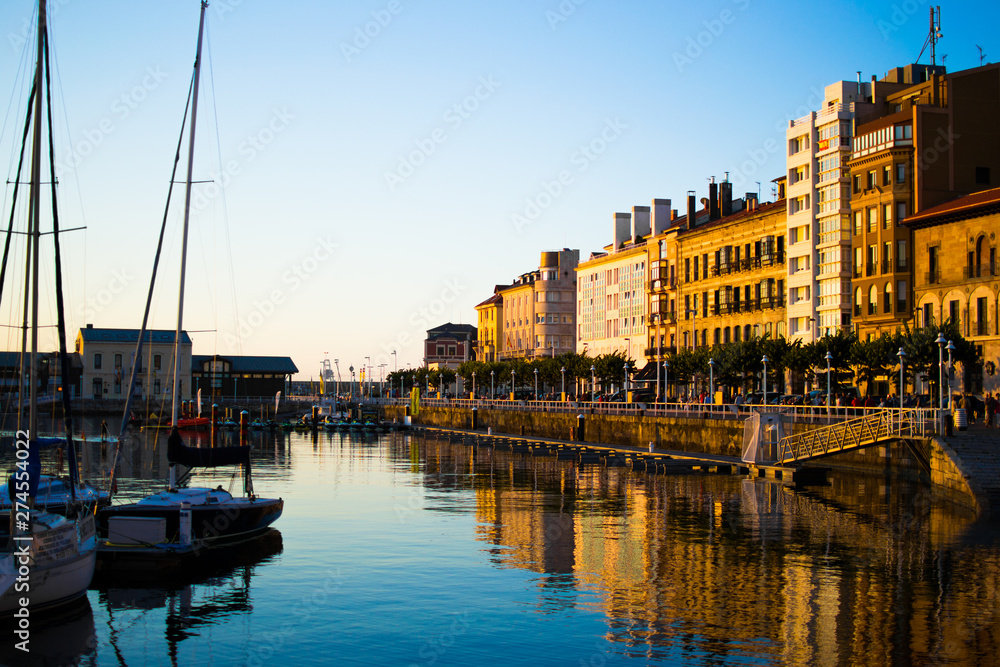View of the dock of Gijon, Asturias, Spain, with reflections in the water, in Cimadevilla, the old town, during the sunset. Peaceful place