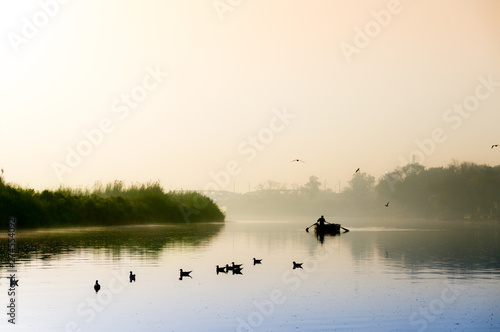 Early morning at yamuna ghat with golden sun, fog and blue water