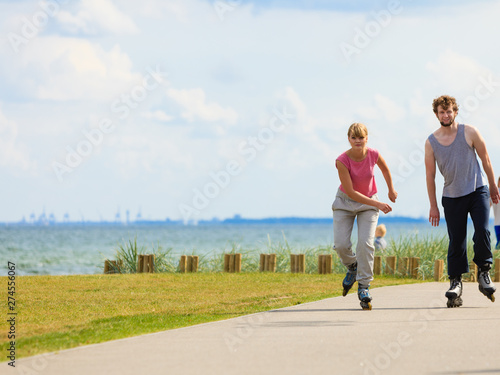 Teen couple together on skates.