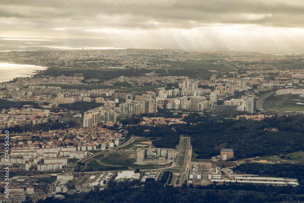 Lisbon from above. City skyline with clouds in the sky. Building and mouth of the river name Tagus with landscape