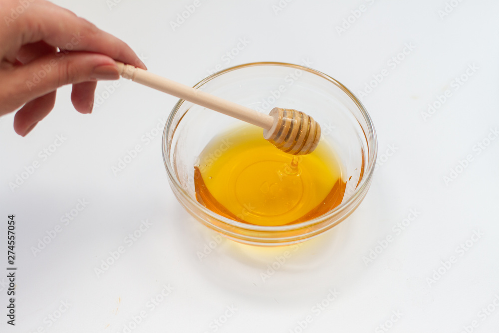 honey in bowl with wooden spoon and a spoon isolated on white honey in bowl with wooden spoon and a spoon isolated on white