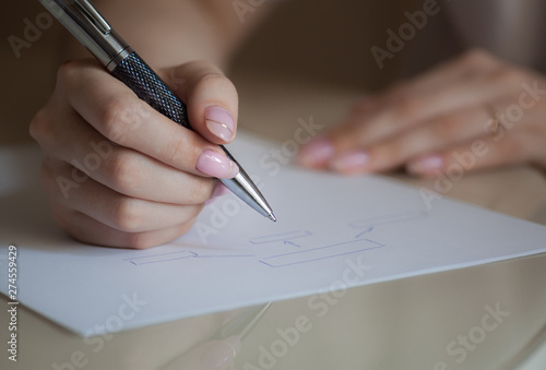 girl draws a diagram and writes on a piece of paper, work and design of business, study, management