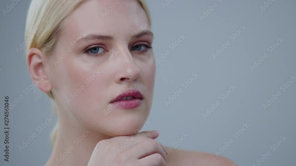 Nude portrait of stunning beauty blonde woman posing in the studio. Close-up of nice-looking girl touching her healthy shining skin face and smiling on camera. Nude portrait of stunning beauty blonde woman posing in the studio. Close-up of nice-looking girl touching her healthy shining skin face and smiling on camera.