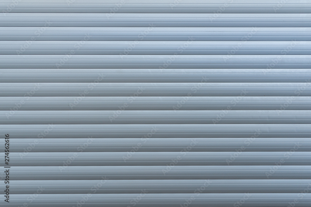 White metal with horizontal linear stripe pattern of rolling shutter door. White metal with horizontal linear stripe pattern of rolling shutter door.