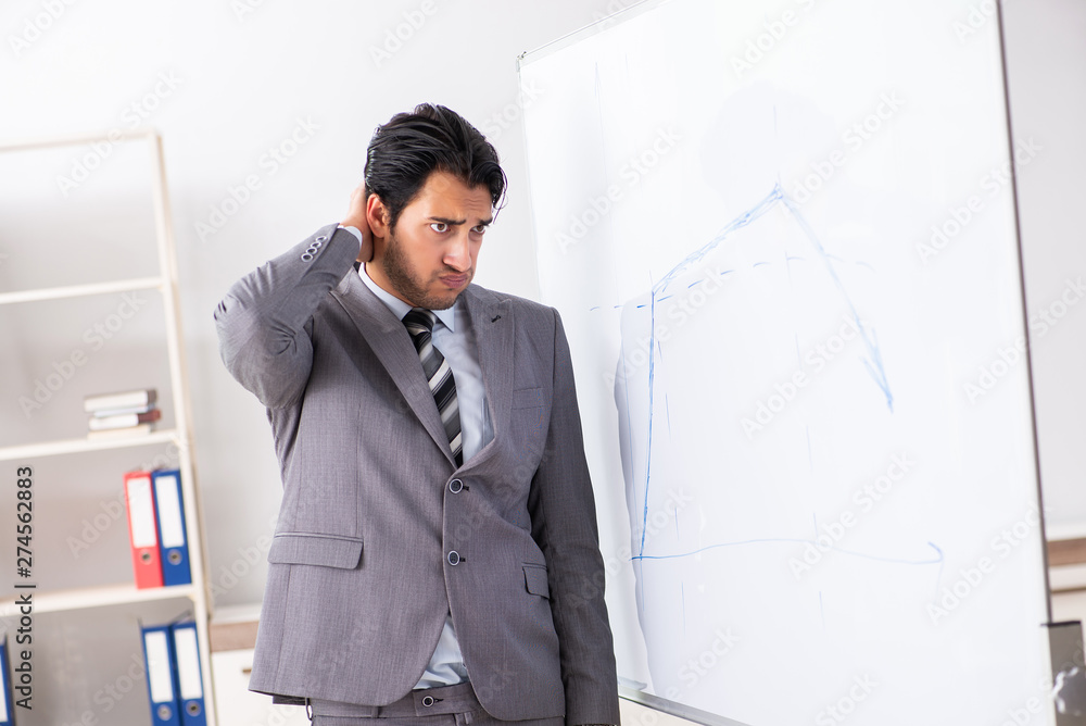 Young handsome businessman in front of whiteboard Young handsome businessman in front of whiteboard