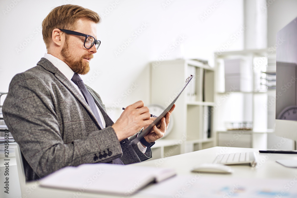 Mid age businessman working on tablet at the office Mid age businessman working on tablet at the office