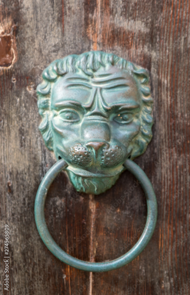 Old rusty iron lion head door knocker on a wooden door. Mdina, Malta