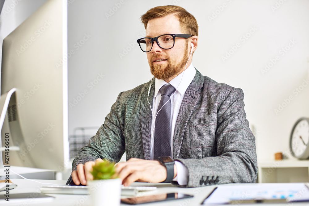 Mid age businessman working on computer at the office Mid age businessman working on computer at the office