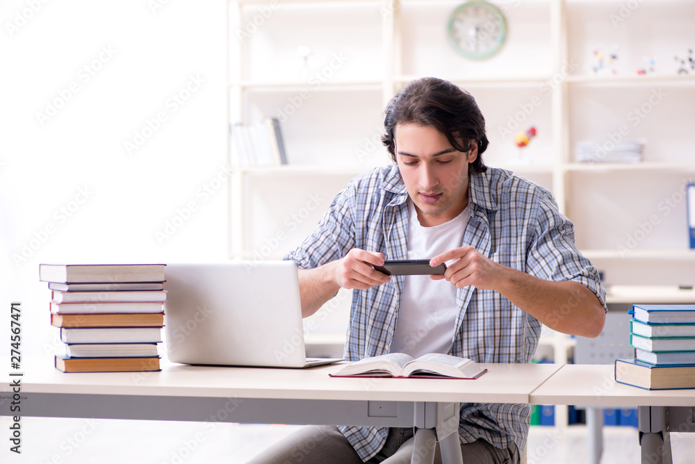 Young male student preparing for exams at home 