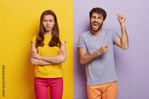 Happy cheering guy raises hands and dances happily, dissatisfied woman doenst...