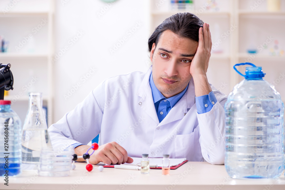 Young male chemist experimenting in lab Young male chemist experimenting in lab