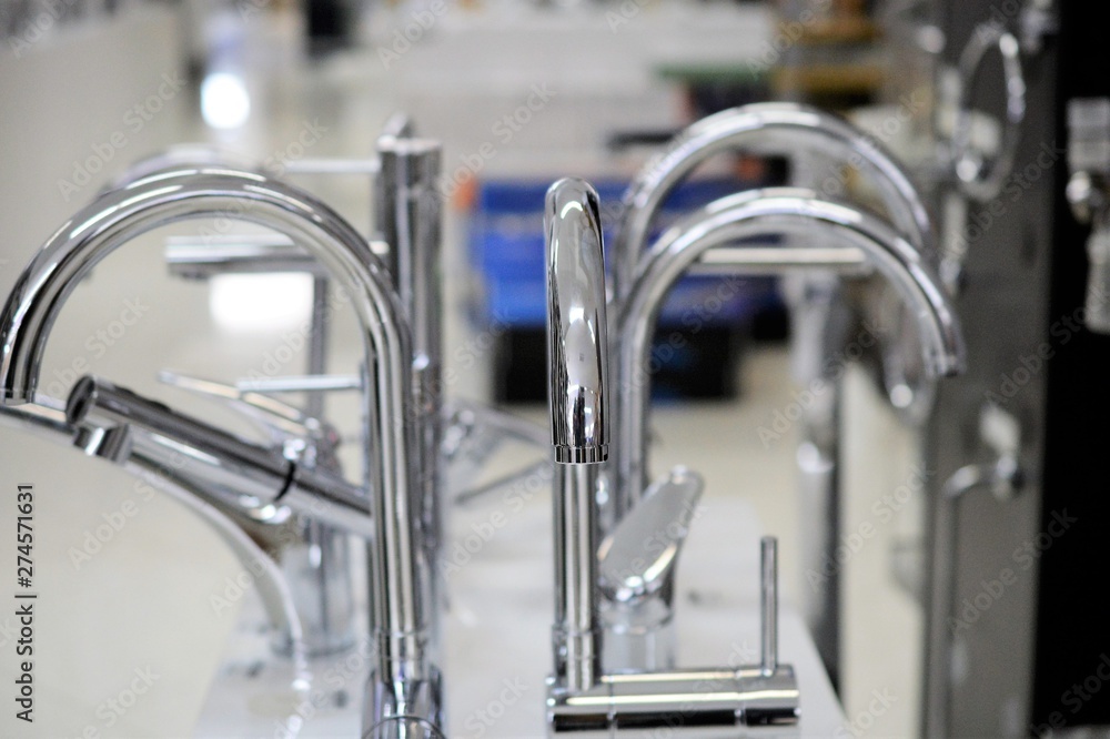 Water faucet, bathroom faucet and kitchen faucet. Chrome-plated metal. shallow dof.Pictured in a shop Water faucet, bathroom faucet and kitchen faucet. Chrome-plated metal. shallow dof.Pictured in a shop
