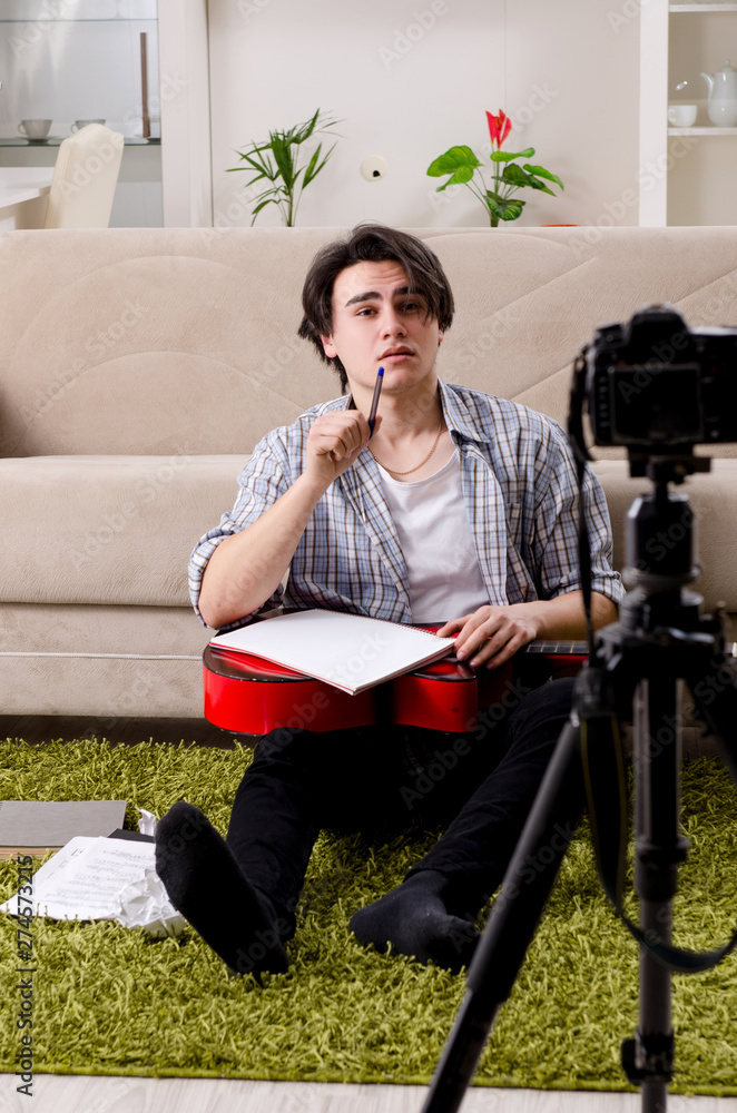 Young guitar player recording video for his blog Young guitar player recording video for his blog