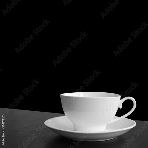 empty white cup for hot coffee or tea and cocoa drink on black or dark wood table for wake up or breakfast in morning and freshness to work office on black background isolated included clipping path