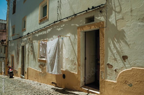 Old colorful houses with rough plaster wall and open door © Celli07