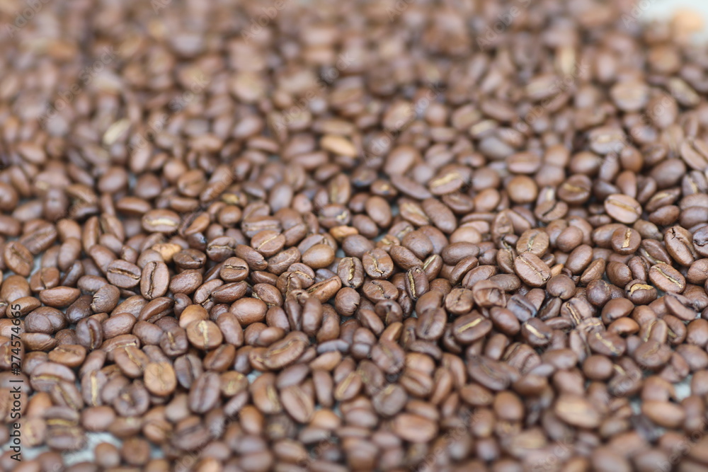 Coffe beans in hands and on the wooden table, roasted arabica Coffe beans in hands and on the wooden table, roasted arabica