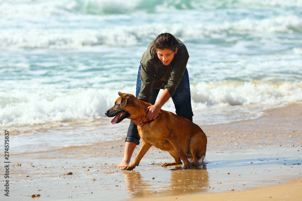 Teenage girl with her dog on the beach Teenage girl with her dog on the beach