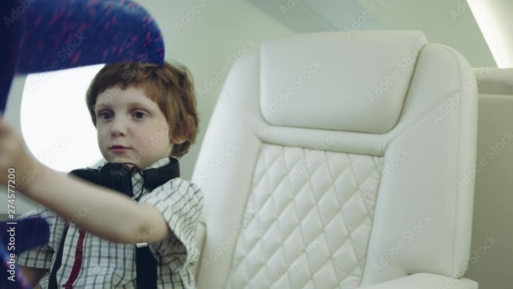 Happy kid with blue toy airplane. Child having fun during the flight on private jetplane. Imagination and freedom concept. RED HELIUM. Happy kid with blue toy airplane. Child having fun during the flight on private jetplane. Imagination and freedom concept. RED HELIUM.