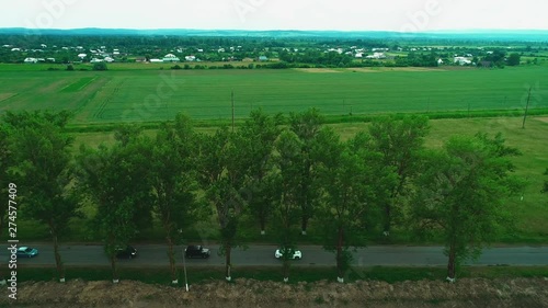 Drone flies over the valley. Afew cars are passing by the road. 4K. photo