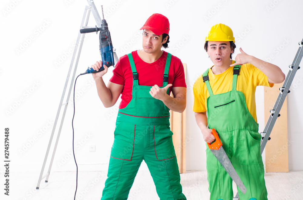 Two workers contractors working indoors Two workers contractors working indoors