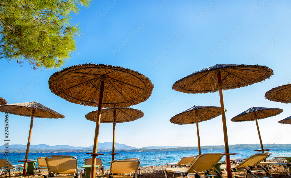 Straw awnings and mainland Greece at  background