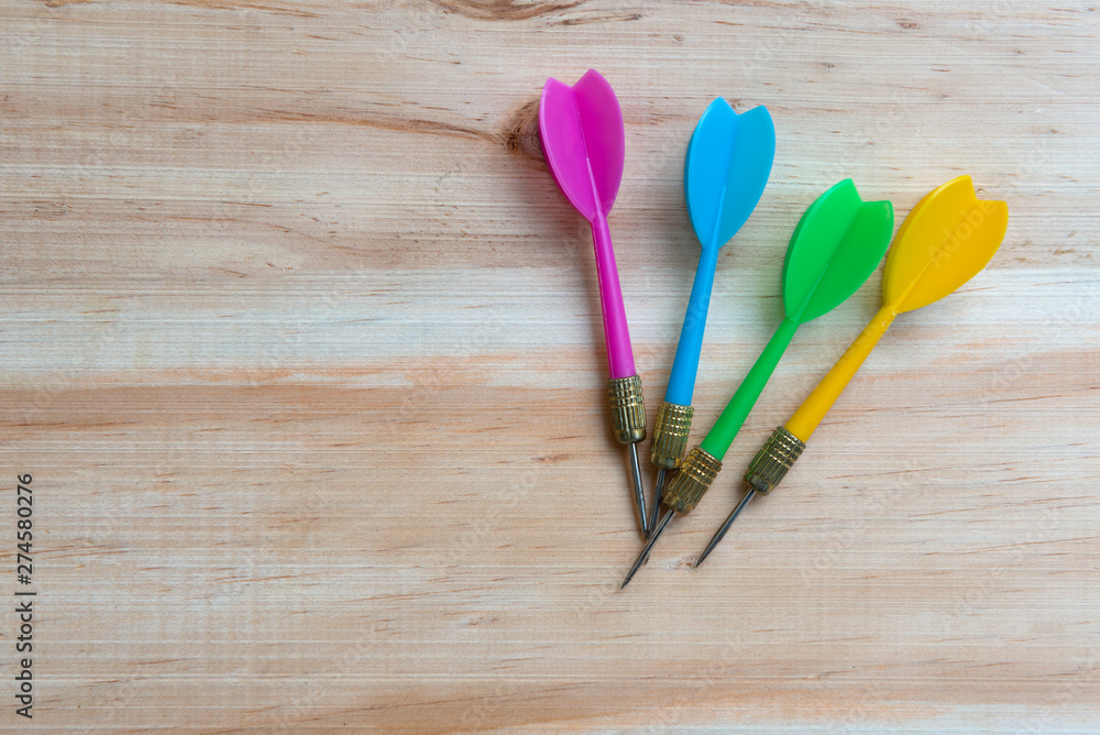 Colourful darts on the wooden table Colourful darts on the wooden table