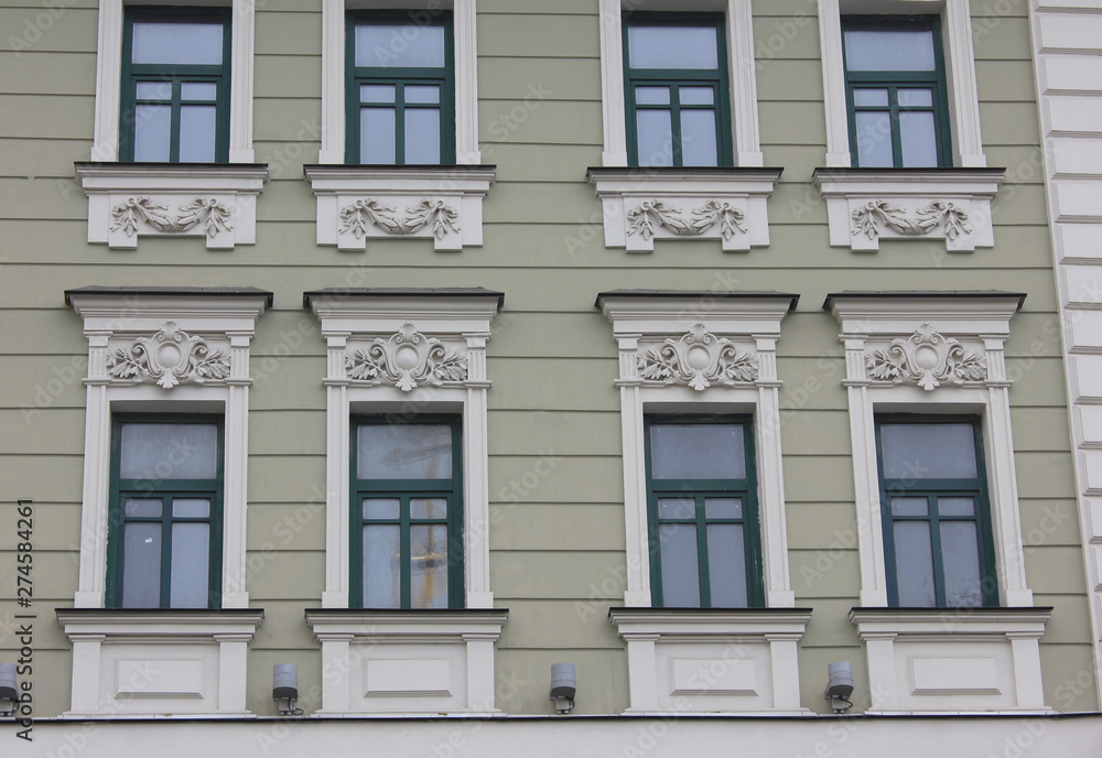 Old historical building facade of classic european house with windows in Moscow, Russia. Russian city typical architecture, close up view of building front facing the street