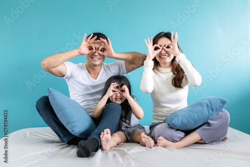 exited asian family mom dad daughter happiness concept with hand pose with on white bed home background