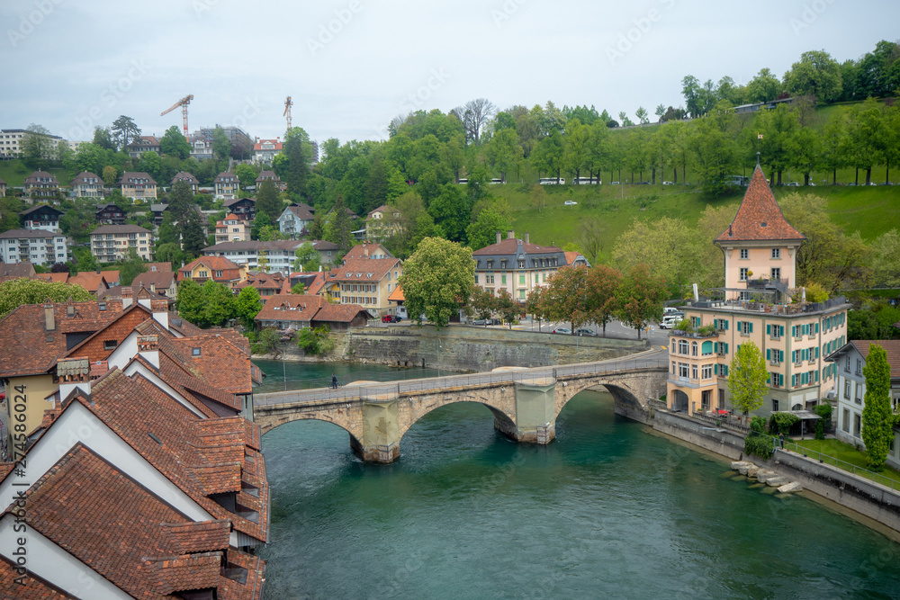 Beautiful view of Nydegg bridge on aare river with charming building and fresh green trees in downtown of Bern, Switzerland