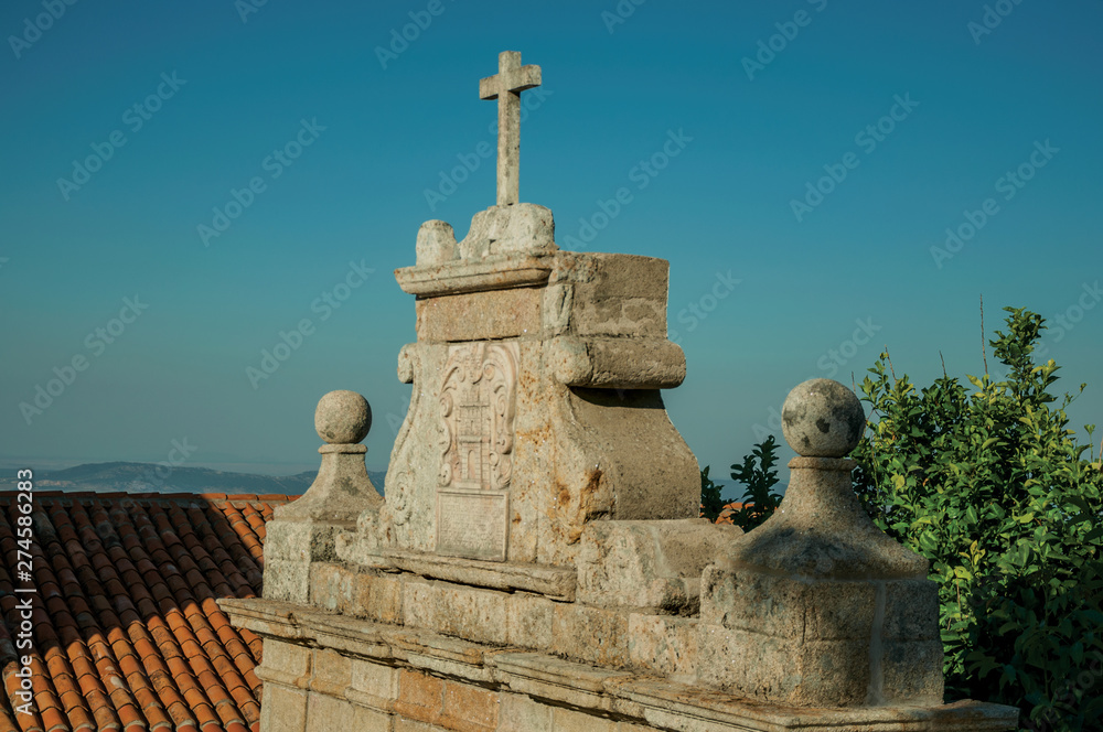 Cross over baroque style wall with the city coat of arms carved in stone