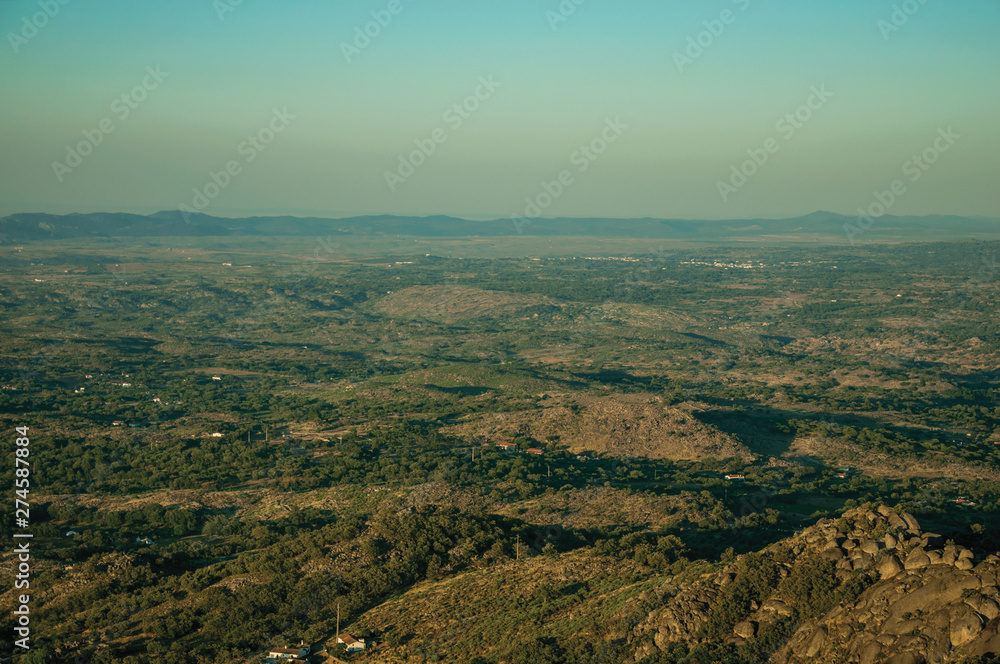 Mountainous landscape covered by trees and cultivated fields
