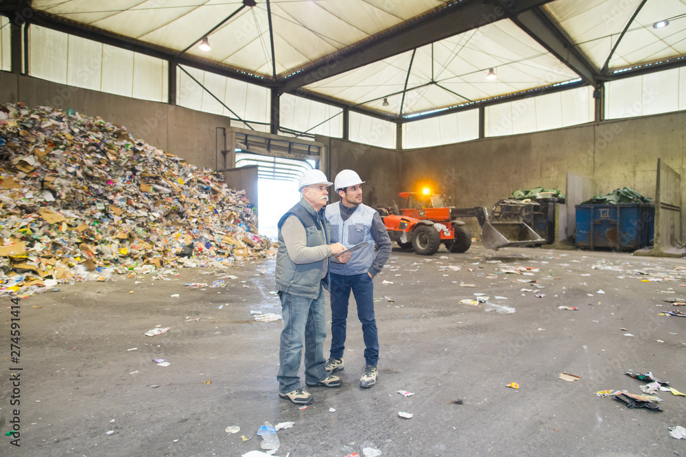 Fototapeta premium full length view of two men in recycling center