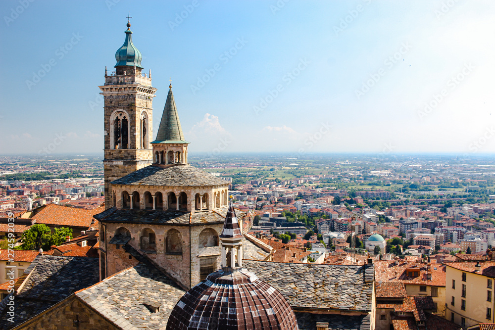 View of a church and Bergamo, Italy from the top of a tower on a hill.